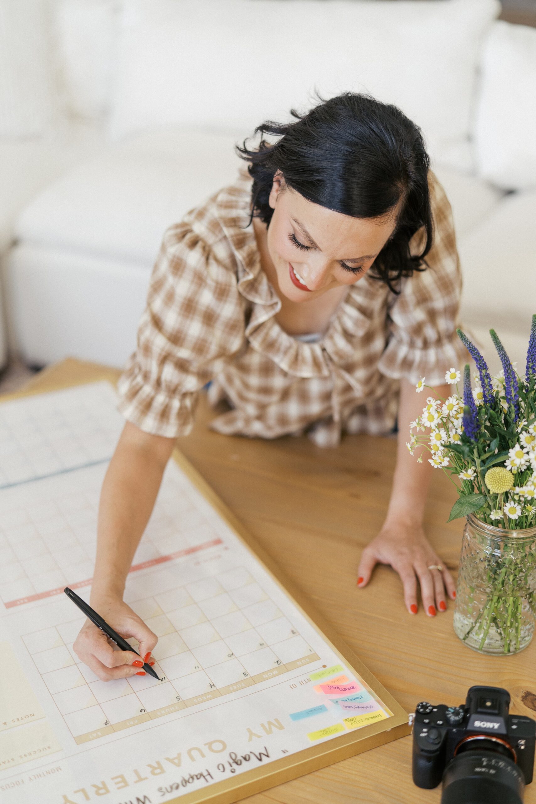 a woman is writing down her marketing plans on a quarterly planner for her branding session