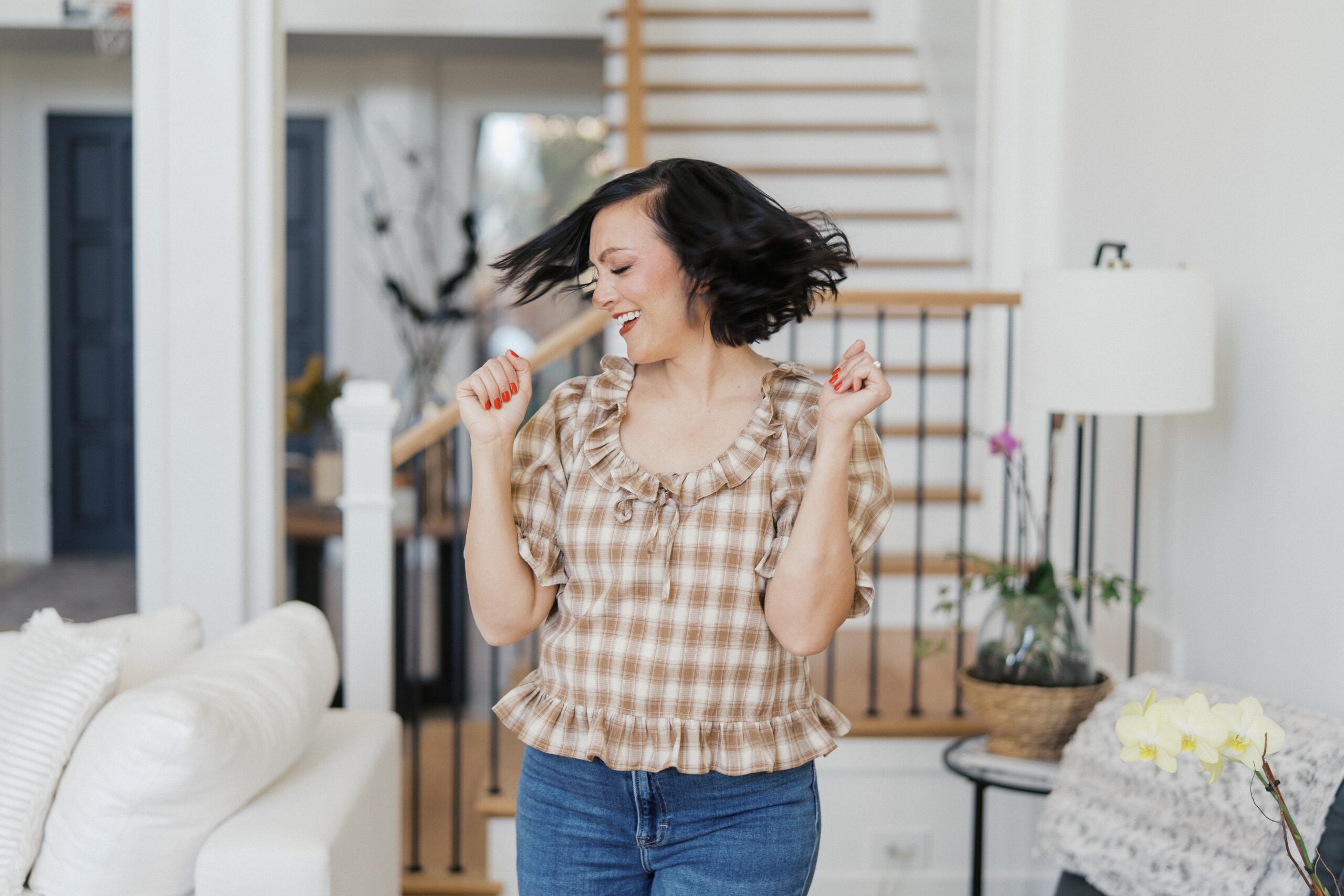a woman wearing a brown and white shirt is dancing for her branding photos